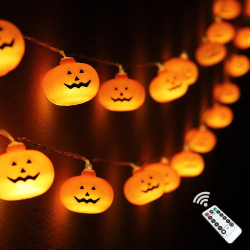 Pumpkin-shaped string lights glowing with warm orange light against a dark background, with a white remote control shown in the lower right corner.